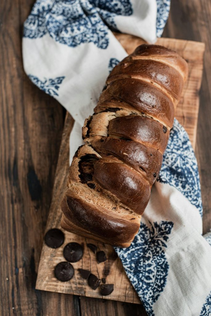 braided-chocolate-bread-on-a-wooden-board-y10syqlwfba